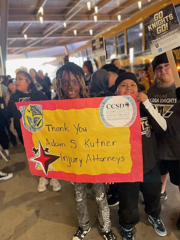 Students holding a sign thanking adam s. Kutner injury attorneys.