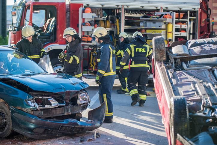 Fatal Auto Accidents 1 Firefighters surround two severely damaged vehicles after a car accident. One vehicle is flipped over.