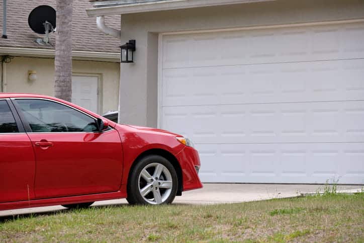 A red car parked in a private driveway.