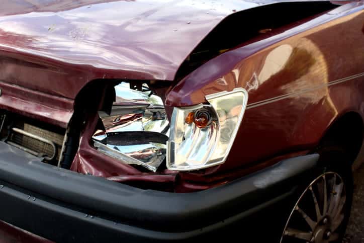 Car accident damage to the front of a red car.