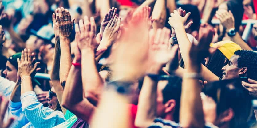 A close-up of fans cheering for a sports team while at a sporting event.