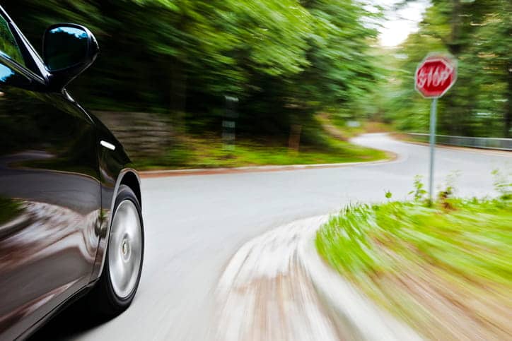 A car speeding past a stop sign.