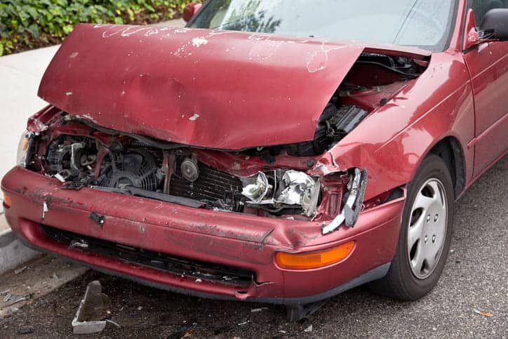 A severely damaged red vehicle after a car accident.