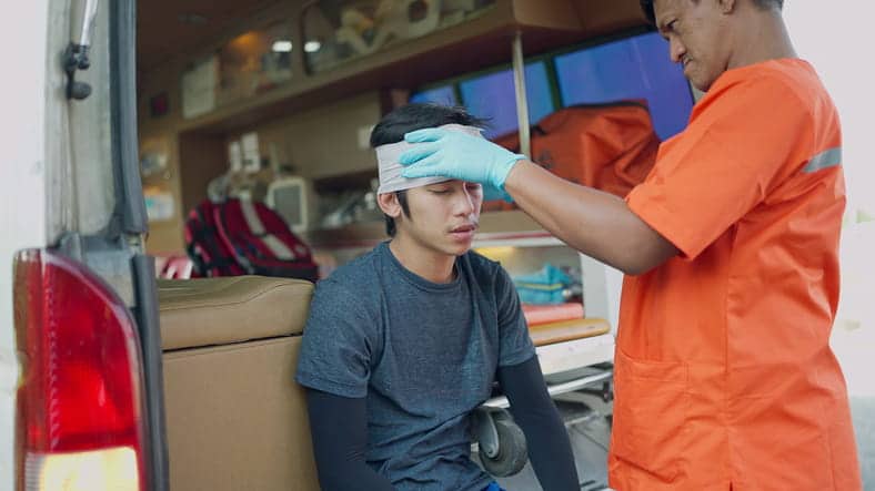 Paradise Brain Injury Lawyer 1 A medic helping someone with a head injury in the back of an ambulance.