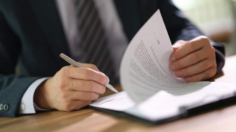 A personal injury attorney discusses paperwork with his client over a case.