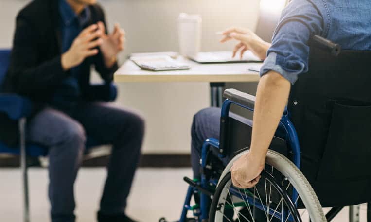 Personal Injury Lawyer Serving Desert Shores, Las Vegas 1 A man in a wheelchair speaks with his personal injury attorney after an accident.