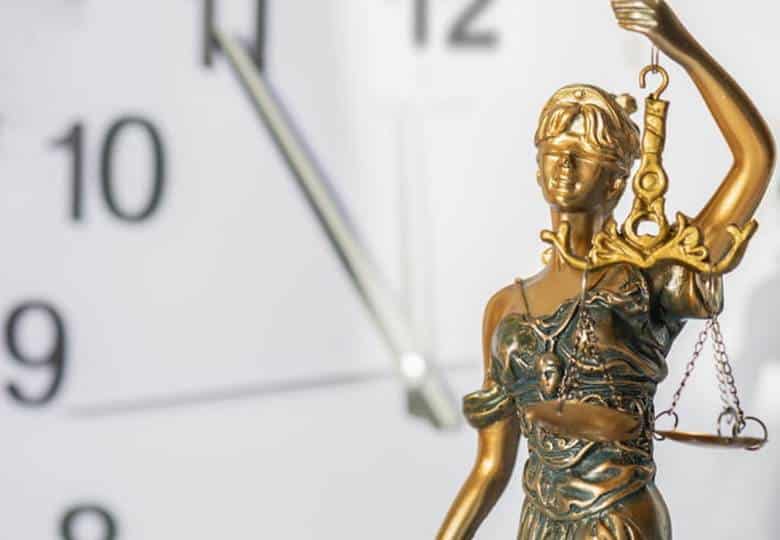 How Long After A Car Accident Can You Claim An Injury? 1 A lady justice statue in front of a clock.
