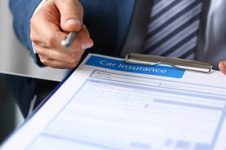 A personal injury attorney is handing car insurance forms to his client.