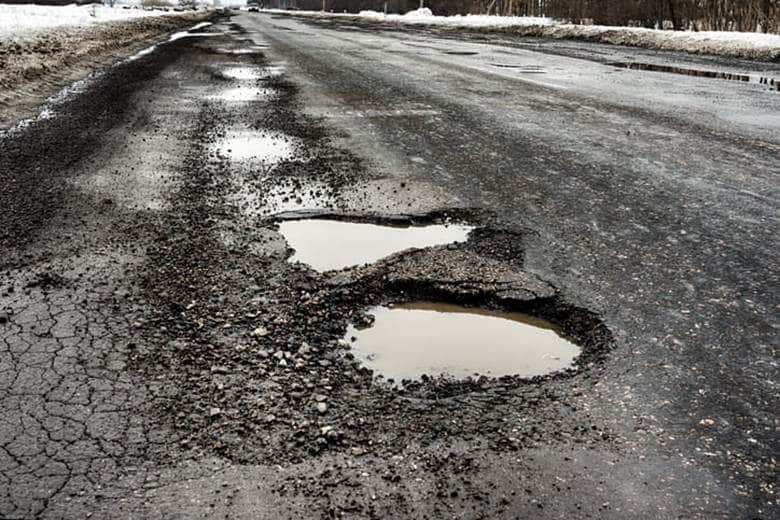 A line of potholes on a hazardous roadway.