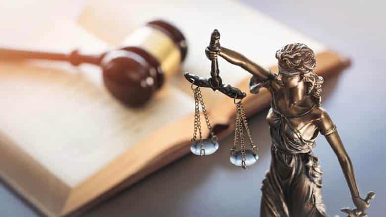 What Is The Difference Between Negligence And Gross Negligence In Nevada? 1 Lady justice next to a law book with a wooden gavel on top of it.