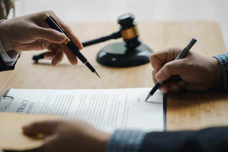 Finalizing Settlement Agreements: Closing The Case Efficiently 23 Two laywers work on a settlement agreement contract.