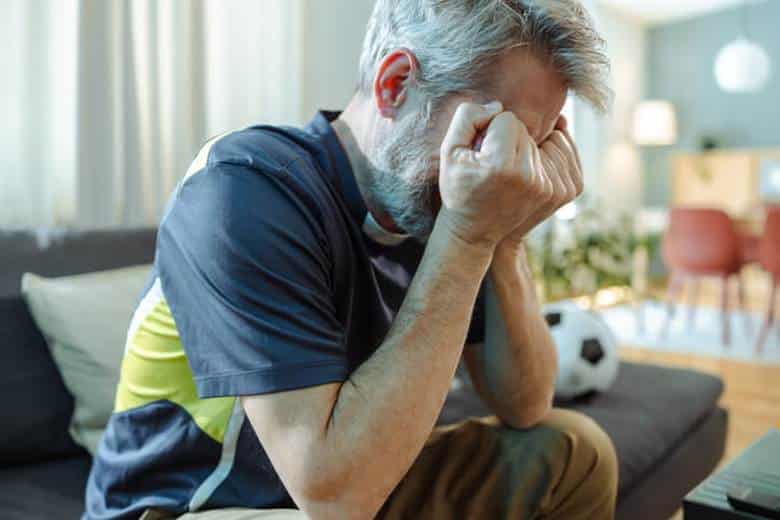 Can I Recover Loss Of Enjoyment Of Life After An Accident? 20 A man covers his face with both hands as he sits in distress.