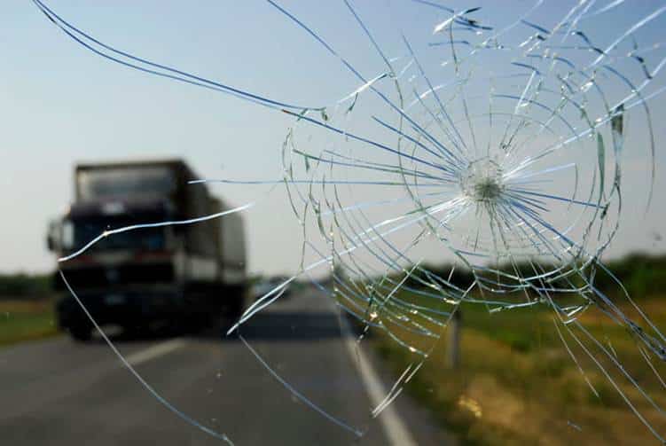 A broken windshield after an accident with a semi-truck.